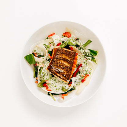 Laxsallad på tallrik mot vit bakgrund